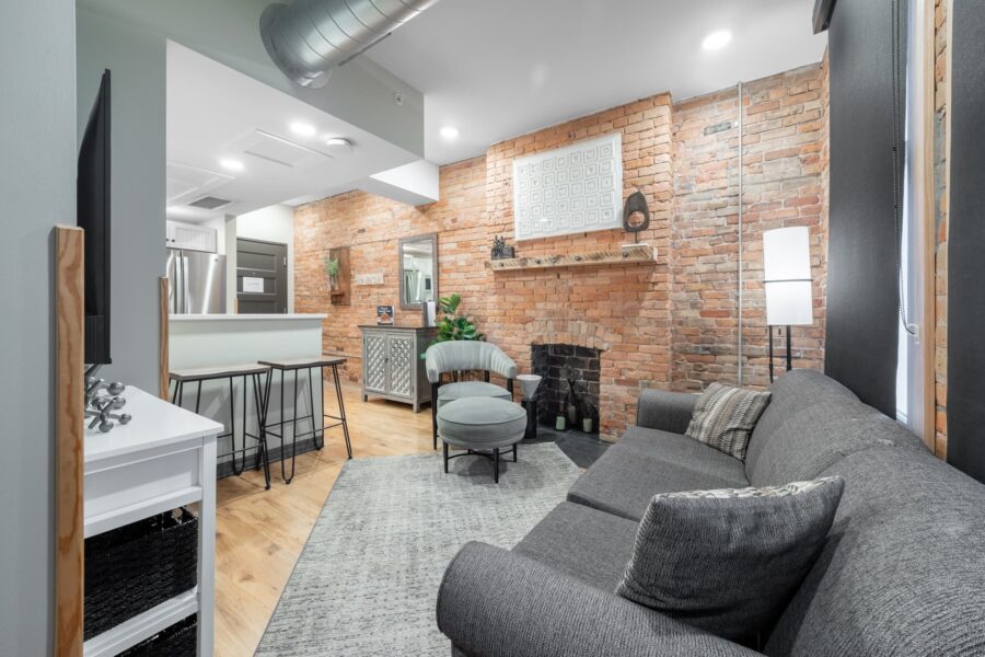 Duluth Rental Suite 201 - Living area with hardwood floors, nice furniture and exposed brick, fireplace