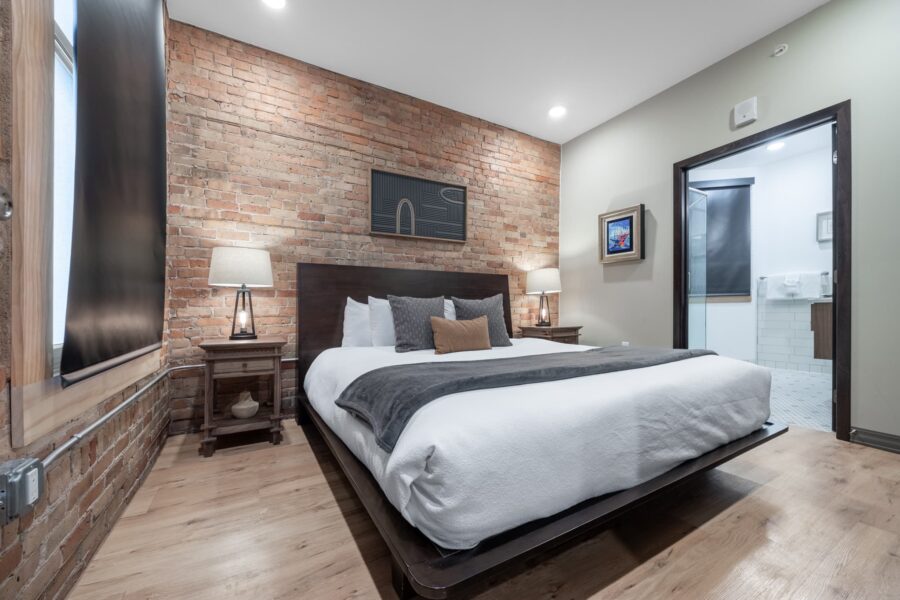 Duluth Rental Suite 201 - Double bedroom with artwork and exposed brick